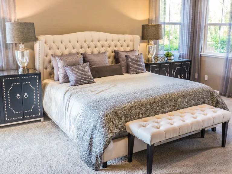 Bedroom with upholstered bed and bedside lamps before packing