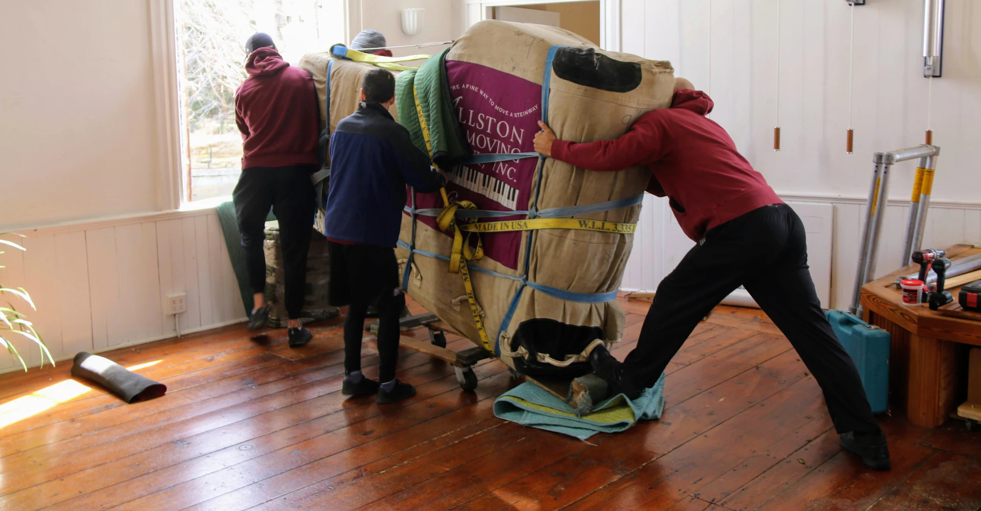 Professional movers carrying household furniture inside a home