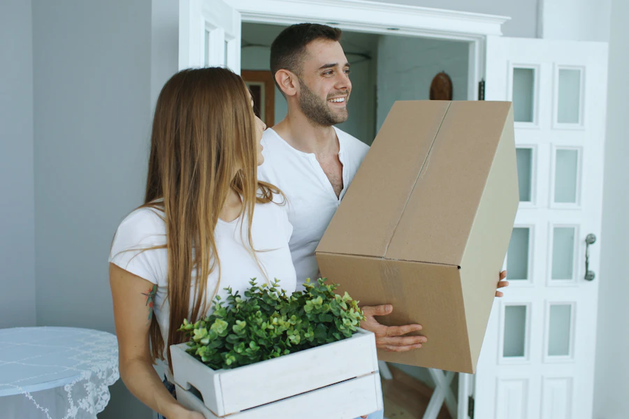 Family carrying moving boxes into their new house